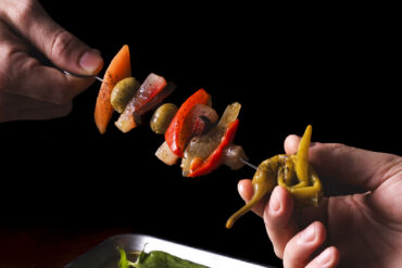 Pinchos con giardiniera fatta in casa, peperoni, olive spagnole, conditi con olio, soia e miele, menu Sapore