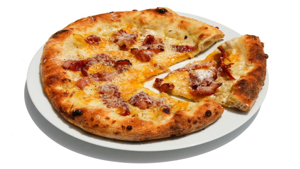 Pizza “Come una carbonara” con crema di datterini gialli,
mozzarella, pancetta affumicata, parmigiano, pecorino e pepe